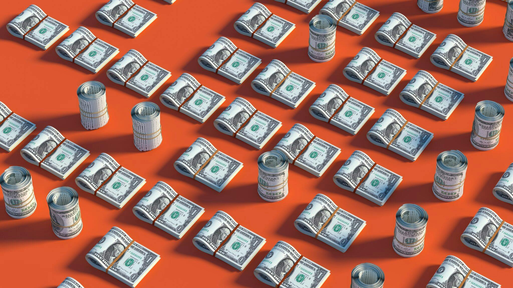 Stacks and rolls of dollars on a orange background